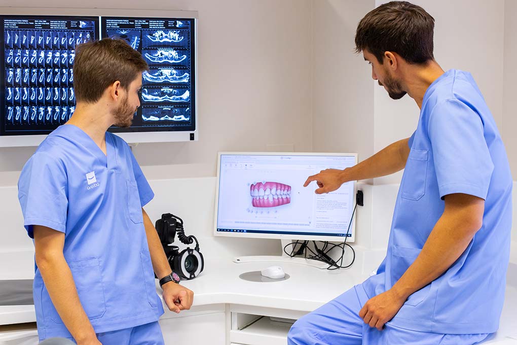 Dos dentistas analizando un caso en el ordenador